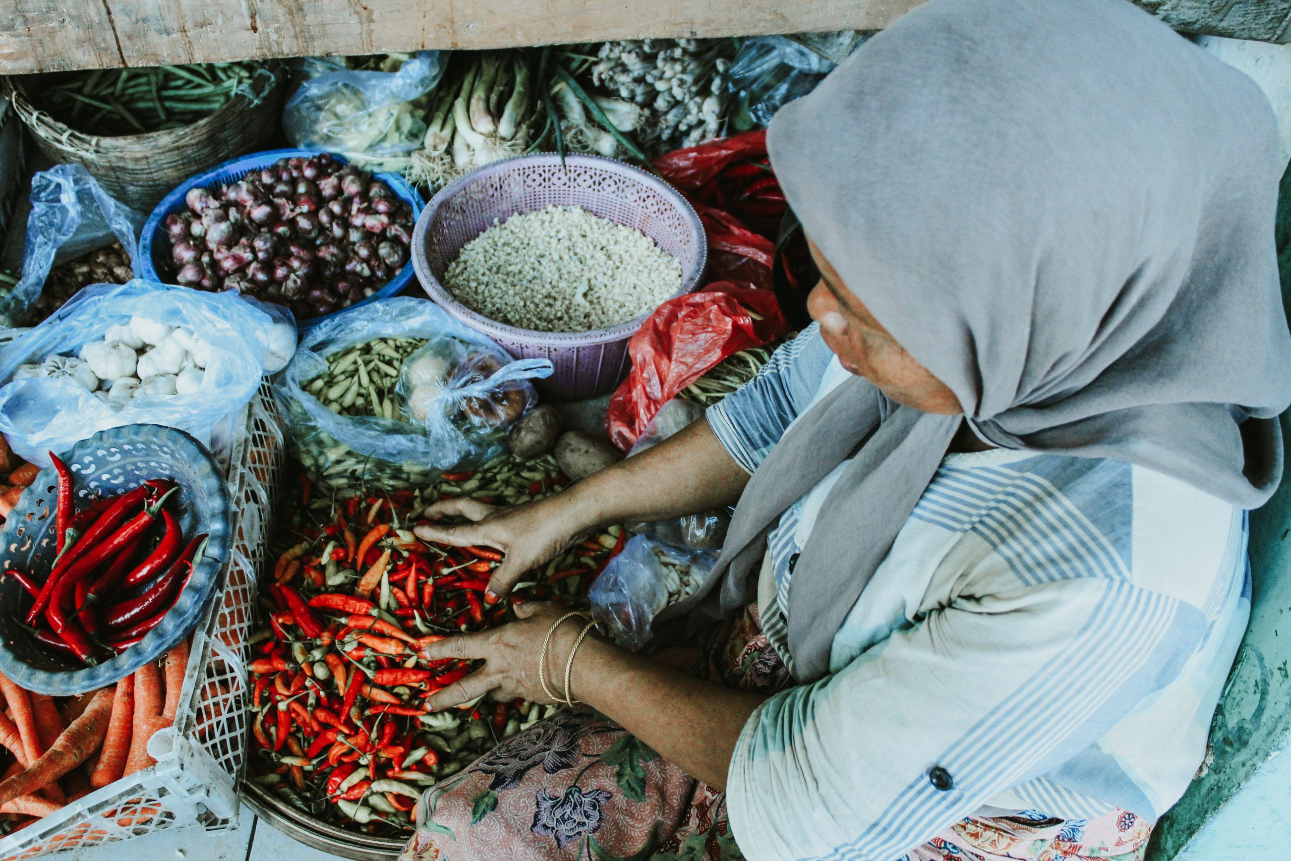 Pedagang perempuan menata sayuran di pasar tradisional Jawa Timur